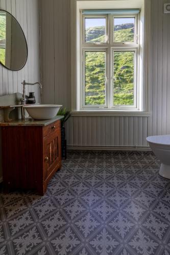 a bathroom with a sink and a tub and a window at Feriehus med flott havutsikt ved Hauklandstranden in Leknes