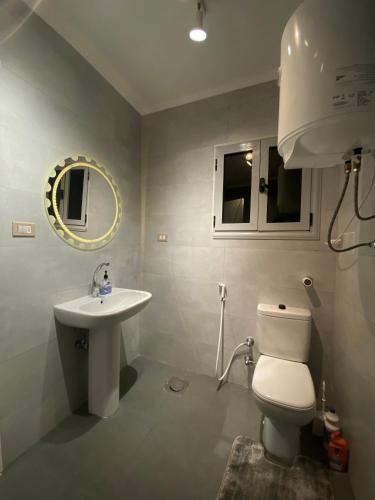 a bathroom with a white toilet and a sink at Hyat Apartments in Alexandria