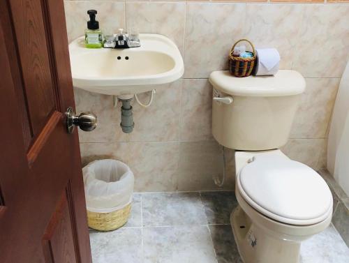 a bathroom with a toilet and a sink at El Pentagono Verde in Arcabuco
