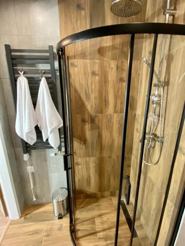 a shower with white towels on a rack in a bathroom at Apartamenty Avia - Energylandia Zator in Spytkowice