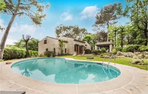 an image of a swimming pool in front of a house at Cozy Home In Roquefort-Les-Pins in Roquefort-les-Pins