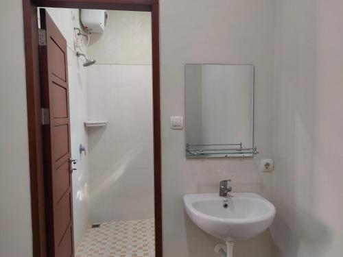 W łazience znajduje się umywalka i lustro. w obiekcie Wiana Homestay w mieście Sanur