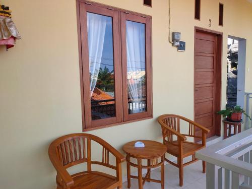 Pokój z 2 krzesłami, stołem i oknem w obiekcie Wiana Homestay w mieście Sanur