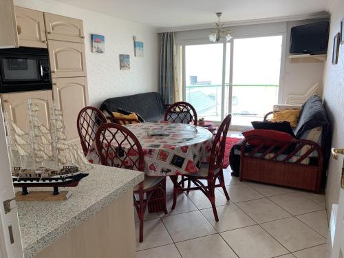Il comprend une cuisine avec une table et des chaises ainsi qu'un salon. dans l'établissement Fort-Mahon-Plage : Appartement 2 Chambres, Parking, Animaux Acceptés, Vue Mer - FR-1-482-106, à Fort-Mahon-Plage