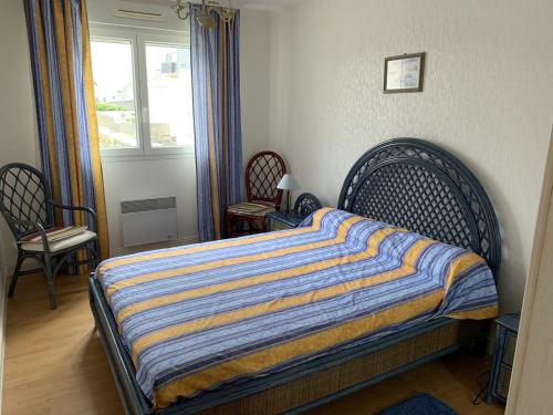 une chambre avec un lit et deux chaises et une fenêtre dans l'établissement Fort-Mahon-Plage : Appartement 2 Chambres, Parking, Animaux Acceptés, Vue Mer - FR-1-482-106, à Fort-Mahon-Plage