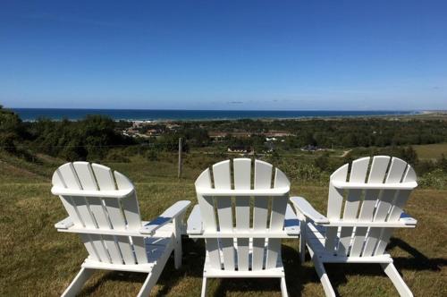 two white chairs sitting on top of a hill at Hotel Nor - Badehotellet in Fjerritslev