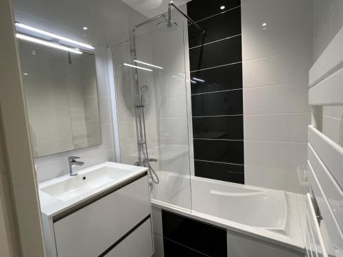 une salle de bain blanche avec une douche et un lavabo dans l'établissement Appartement avec aperçu mer et piscine aux Sables-d'Olonne - FR-1-485-137, à Les Sables-dʼOlonne