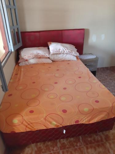 Bett in einem Schlafzimmer mit rotem Kopfteil in der Unterkunft Hospedaje Margarita in Encarnación
