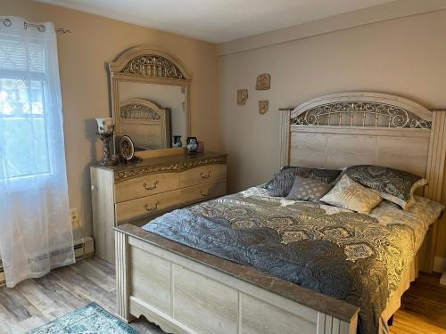 ein Schlafzimmer mit einem großen Bett und einer Kommode in der Unterkunft Village at Winnipesaukee 59 Treetop #432 in Laconia