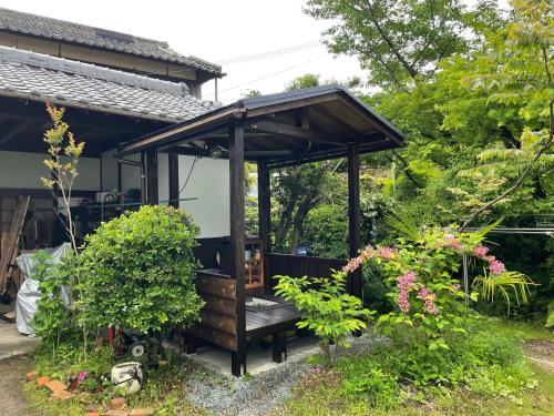 a gazebo with a bench in a garden at 淡路島 サウナ宿たんざ in Awaji