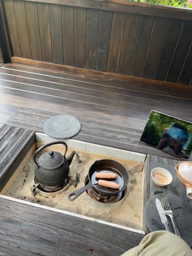 a grill with a pot and a hot dog on it at 淡路島 サウナ宿たんざ in Awaji