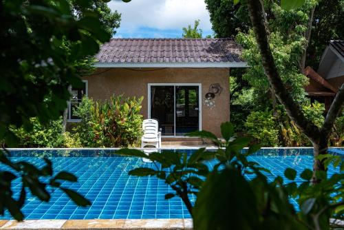 a villa with a pool and a house at Muntra Garden Resort in Sattahip