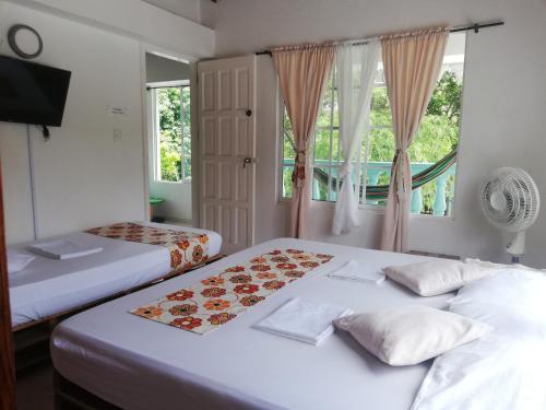 2 camas en una habitación con ventana en Queen Elizabeth Natural Luxury, en San Andrés