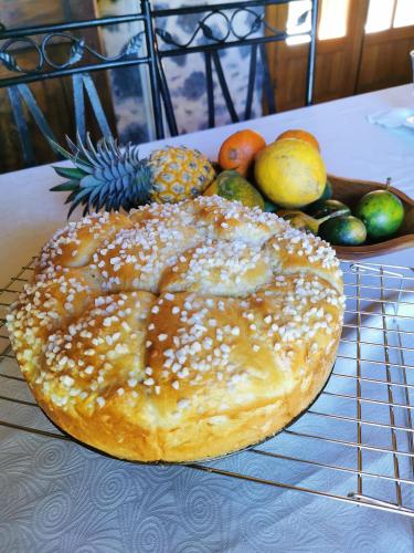 a bagel sitting on a cooling rack next to a bowl of fruit at Les Grands Monts in Saint-Joseph