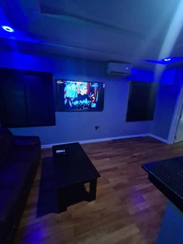 a living room with a couch and a tv on a wall at Wine House, Maitama, Abuja in Abuja