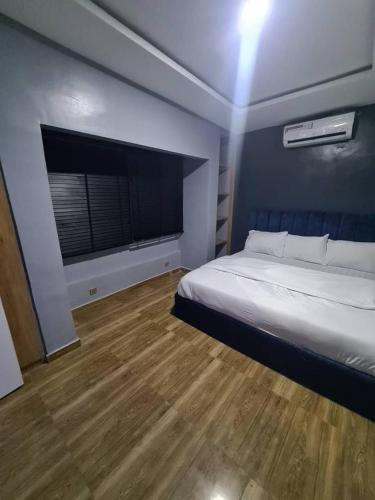 a bedroom with a bed and a large window at Wine House, Maitama, Abuja in Abuja