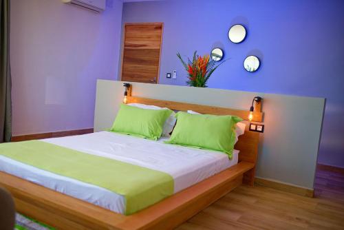 a bedroom with a large bed with green pillows at Villa Vintana Nosy Be in Nosy Be
