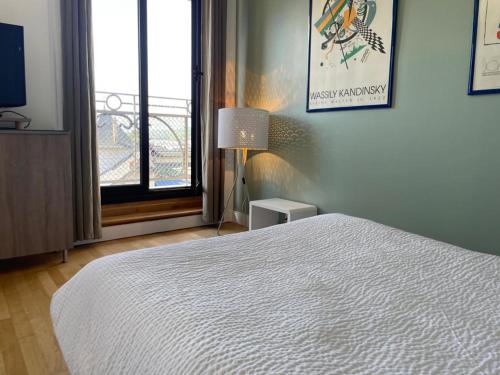 een slaapkamer met een wit bed en een raam bij Studio Aix-les-Bains, 1 pièce, 2 personnes - FR-1-617-43 in Aix-les-Bains