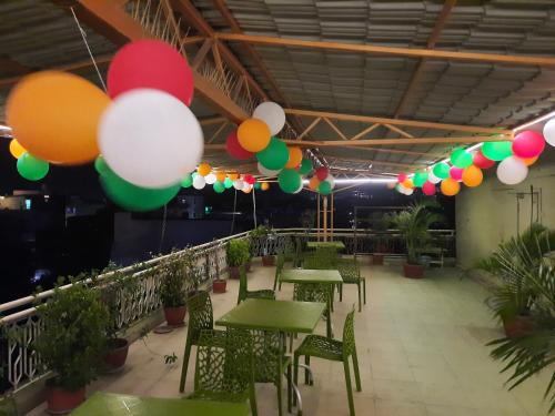 a row of tables with colorful balloons hanging from the ceiling at Hotel Temple On Ganges in Varanasi
