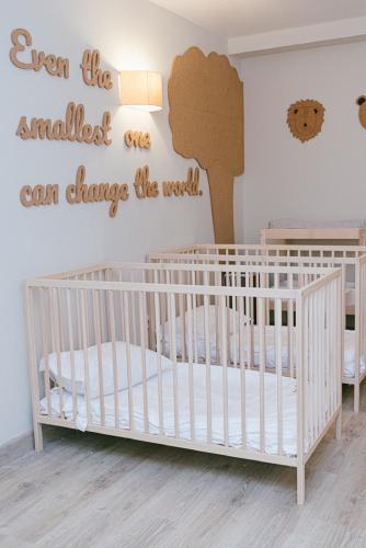 a baby room with a crib with a sign that reads even the smallest ones can at Conimbriga Hotel do Paço in Condeixa a Nova