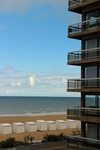 a view of the beach from the balcony of a building at Duinroos C2 in Koksijde