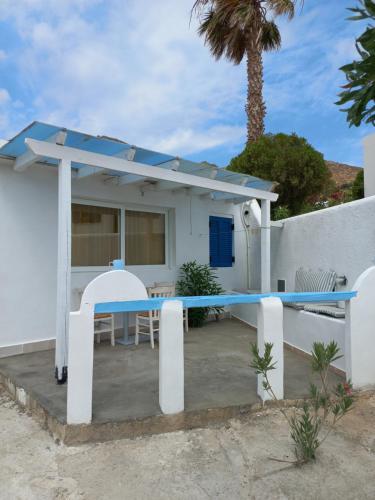 Una casa con una mesa y sillas delante de ella. en Serifos Sunset, en Livadakia