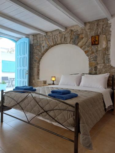 een slaapkamer met een groot bed en een stenen muur bij Serifos Sunset in Livadakia