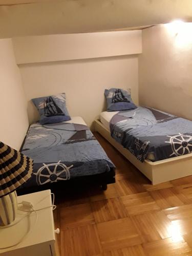 um quarto com 2 camas e piso em madeira em L'anthurium de l'Opéra em Nice