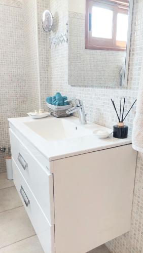 a white bathroom with a sink and a mirror at Villa Christina in Protaras
