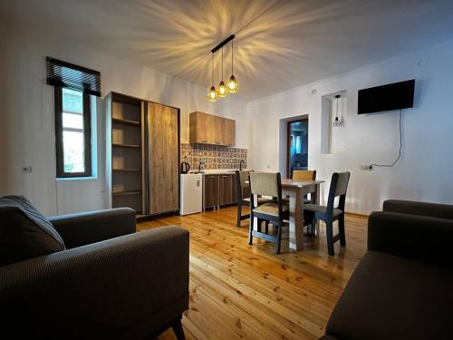 a living room with a table and chairs and a kitchen at Guesthouse Data in Mestia