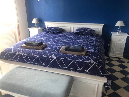 ein blaues Schlafzimmer mit einem Bett mit Handtüchern darauf in der Unterkunft Au Clair de la Pierre - Chambres d'hôtes in Siccieu-Saint-Julien-et-Carisieu