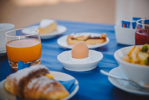 a table with plates of food and an egg and a glass of juice at Hotel San Francisco in Viareggio