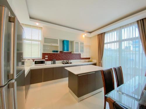 a kitchen with a refrigerator and a table at Twenty Two Pool Villa in Pattaya