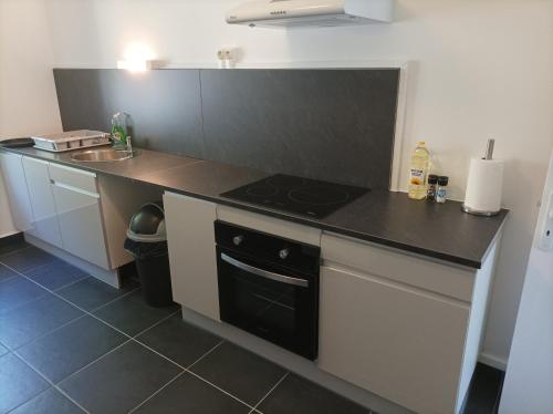 a kitchen with a stove and a counter top at O'Couvent - Appartement 125 m2 - 5 chambres - A524 in Salins-les-Bains