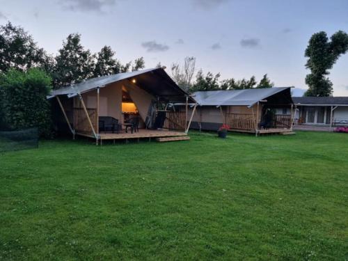 a large tent in a yard next to a house at Camping de Tulpenweide in Breezand