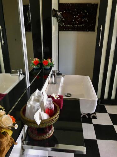 a bathroom with a sink and a mirror at Naraya Homestay in San Pa Tong