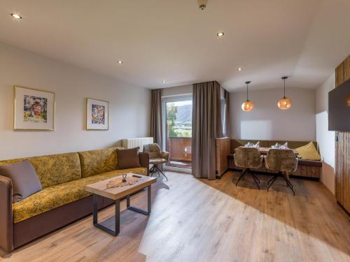 a living room with a couch and a table at Aparthotel Bergland in Söll
