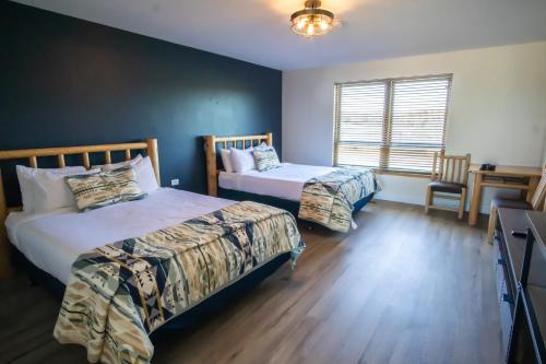 a bedroom with two beds and a table and a window at Teton Peaks Resort in Tetonia
