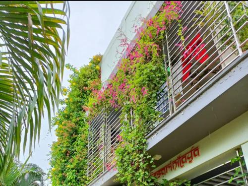 a building with flowers on the side of it at Mango Tree Homestay in Hampi