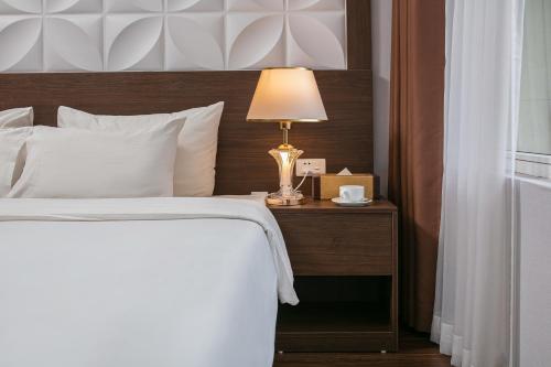 a bedroom with a bed with a lamp on a night stand at Hanoi Diamond King Hotel & Travel in Hanoi
