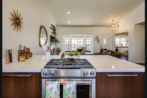 a kitchen with a stove and a living room at Breathtaking Roadrunner Heights in Joshua Tree