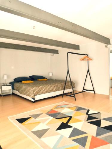 1 dormitorio con cama y alfombra en el suelo en Bordeaux centre historique: Charmant Duplex en Burdeos