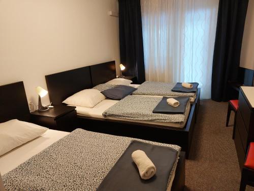 two beds in a hotel room with towels on them at Guesthouse ob Sotočju Budič in Brežice
