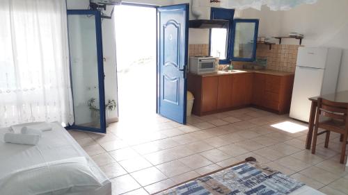 a room with a kitchen with a bed and a refrigerator at Studios Avra in Akhladherí