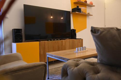 un soggiorno con TV e tavolino da caffè di Apartman Mosaic a Doboj