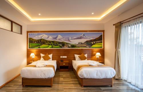 a hotel room with two beds and a painting on the wall at Manigram Bishram Batika Pvt Ltd in Bhairahawa