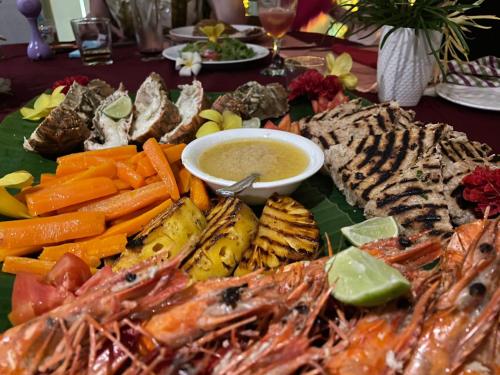 a plate of food with seafood and dipping sauce at La Perla Bentota in Bentota
