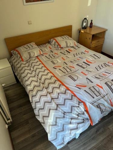 1 cama con edredón y almohadas en Maison Noordburg Veurne en Veurne