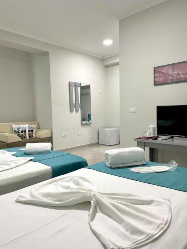 a room with two beds and a tv on the wall at Hotel New York in Kamëz