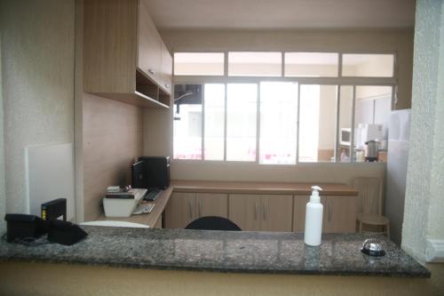 a kitchen with a counter with a sink and a window at Hotel Jurubatuba in São Bernardo do Campo